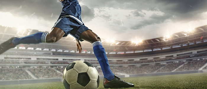 Soccer Sports Betting Picks - Stadium view - player kicking soccer ball